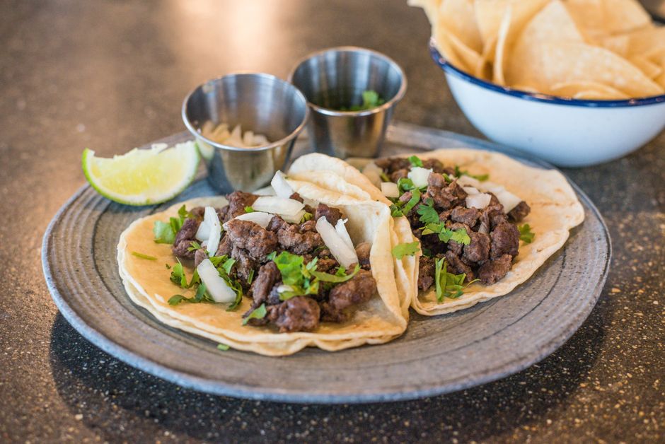 A plate of street tacos with salsa